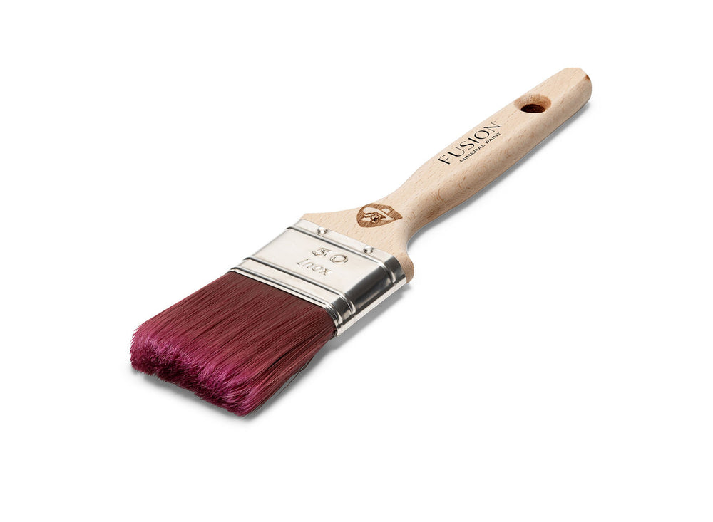 A high-quality flat paintbrush with a natural wood handle and magenta-colored bristles. The metal ferrule secures the bristles to the handle. The brand is Staalmeester.